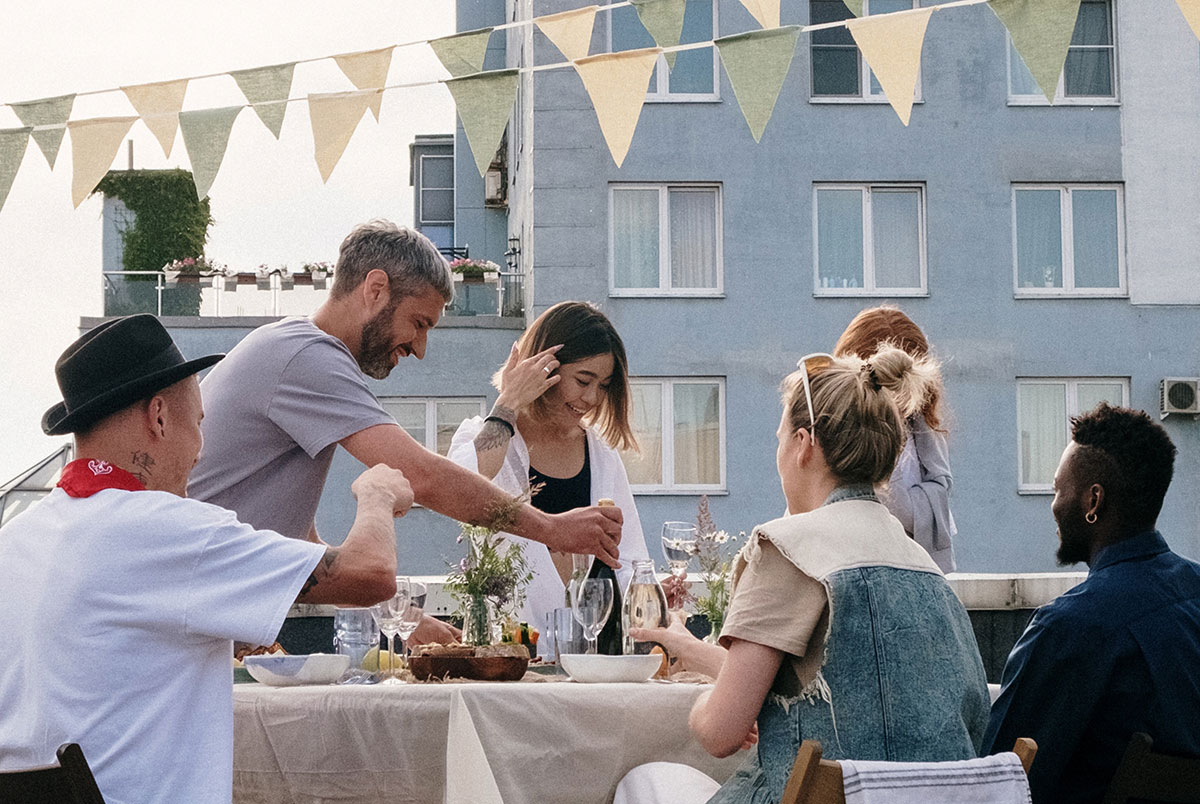 Fiends on a terrace with bunting enjoying a dinner at sunset