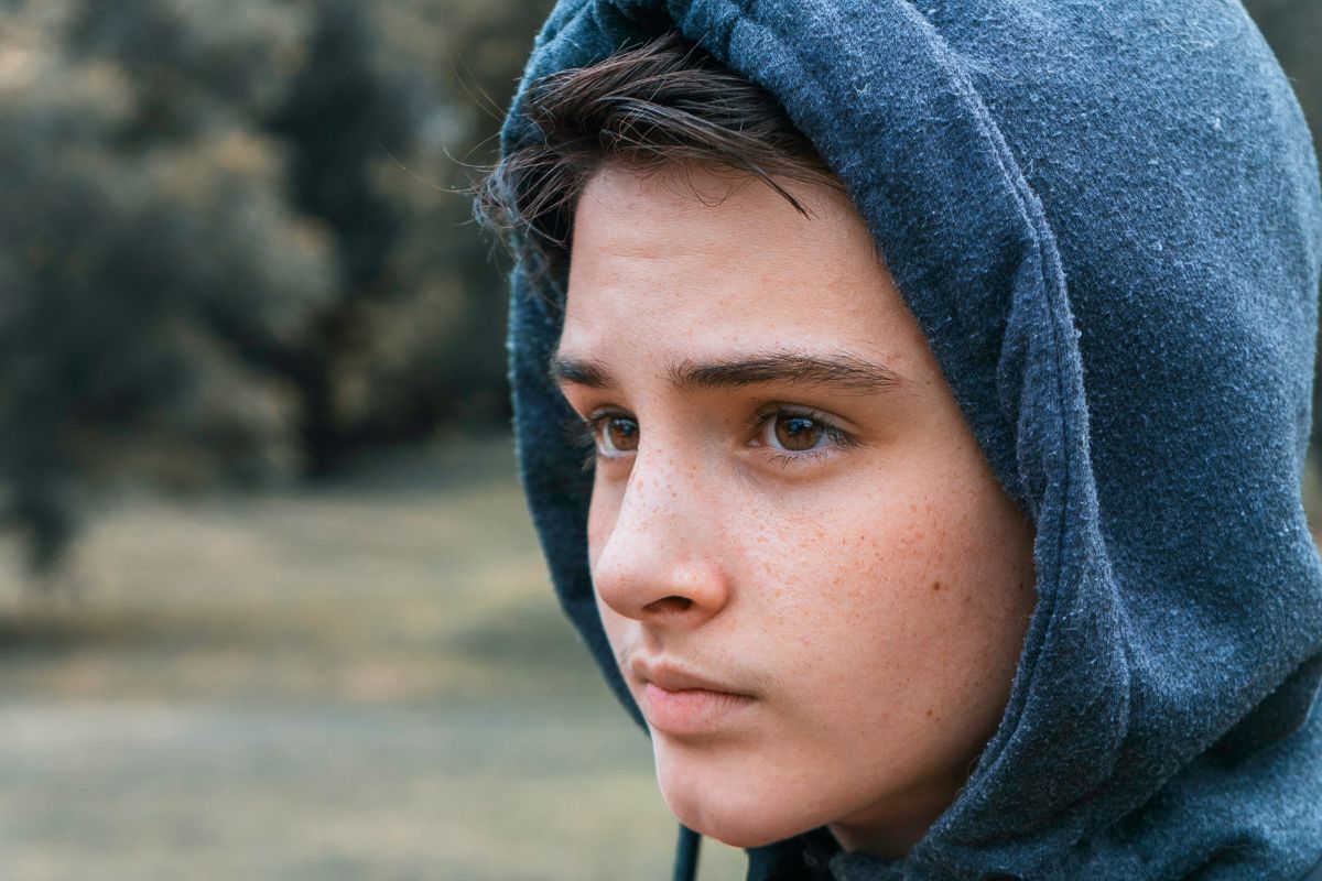 Boy wearing navy hoodie looking away from camera