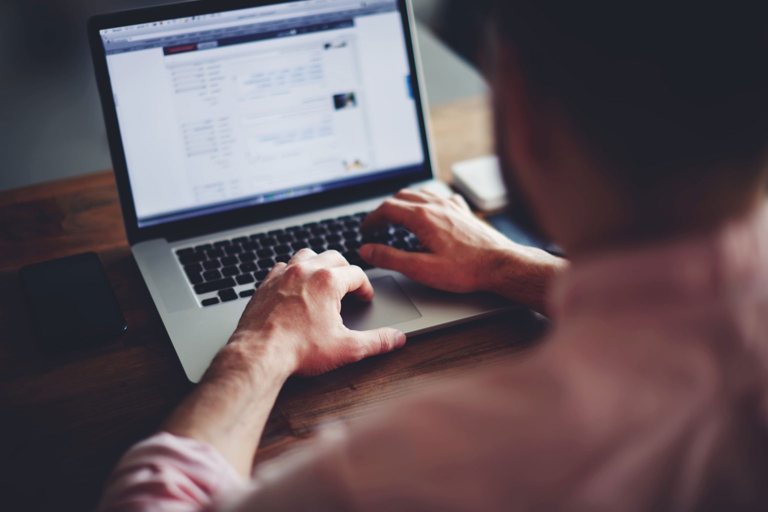 Man typing on laptop while sitting at desk