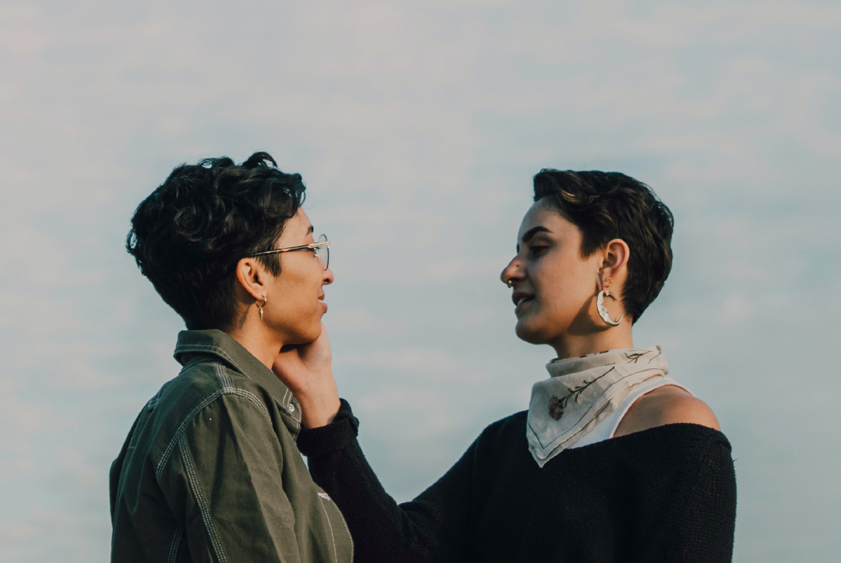 Woman holding hand to the cheek of another woman