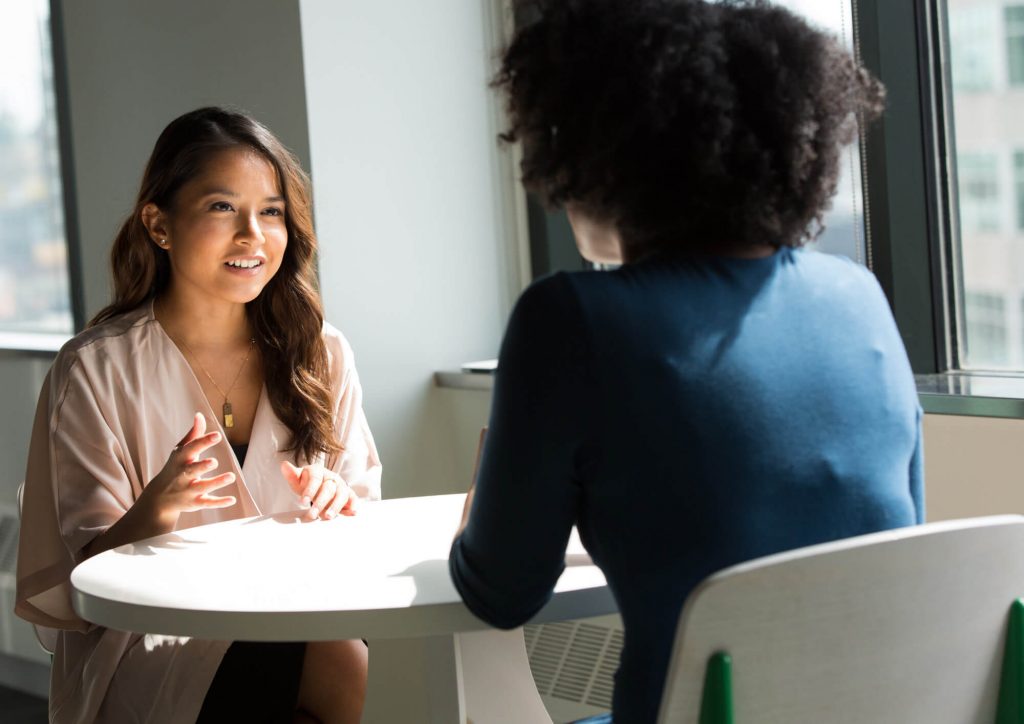 Two women talking to each other.