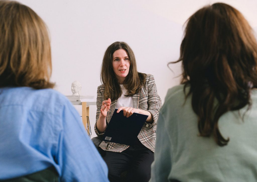 Woman talking to two people.