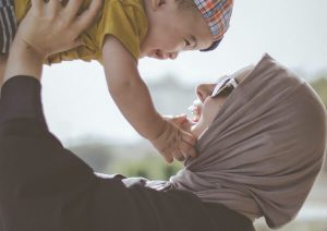 Mother holding up baby son.