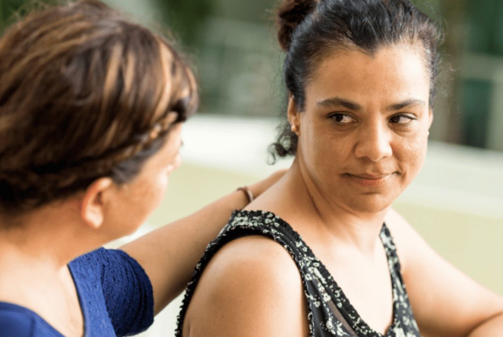 Woman with hand on the shoulder of another woman