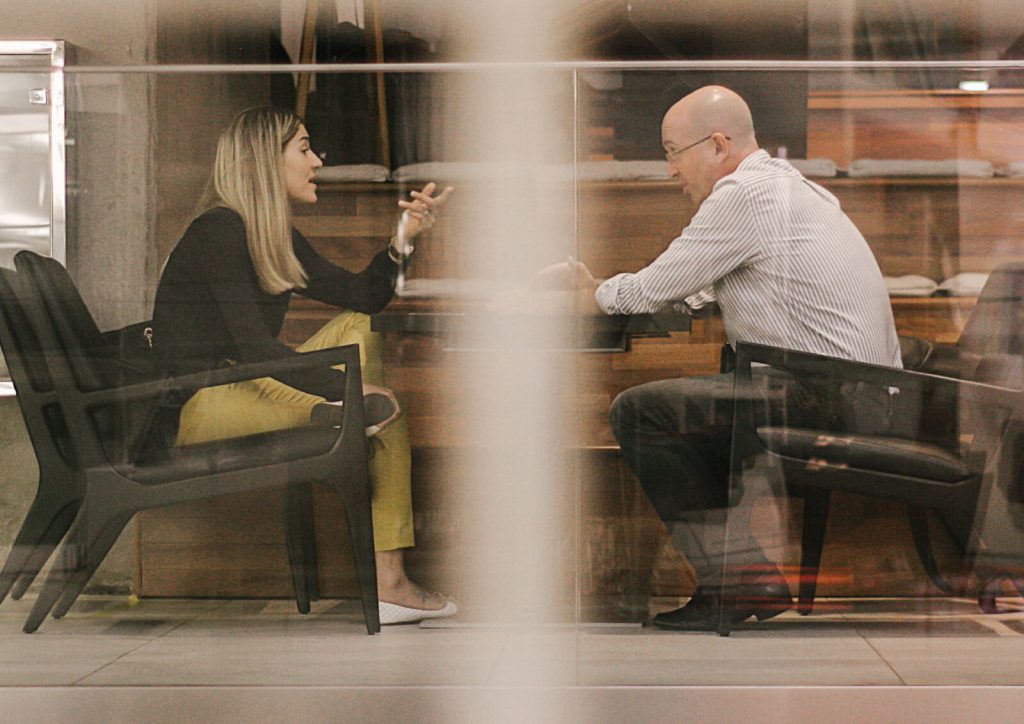 Two people talking to each other across a table.