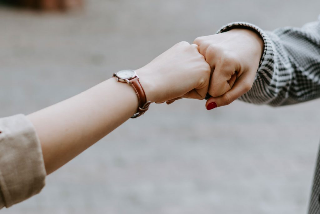 Two hands fist-bumping.