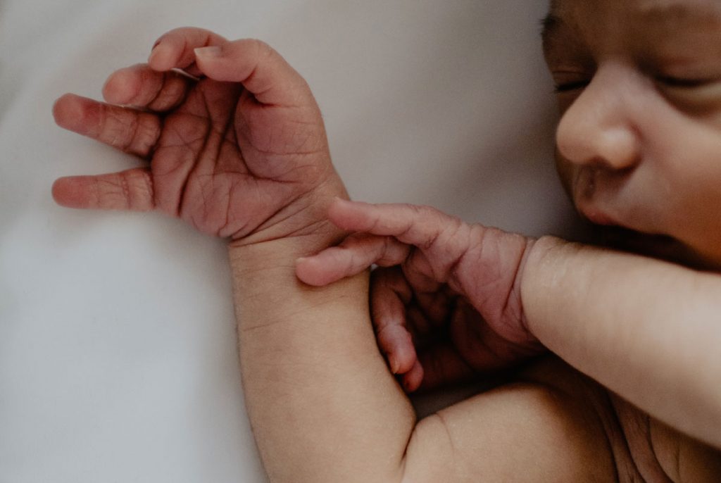 The hands and face of a sleeping baby.