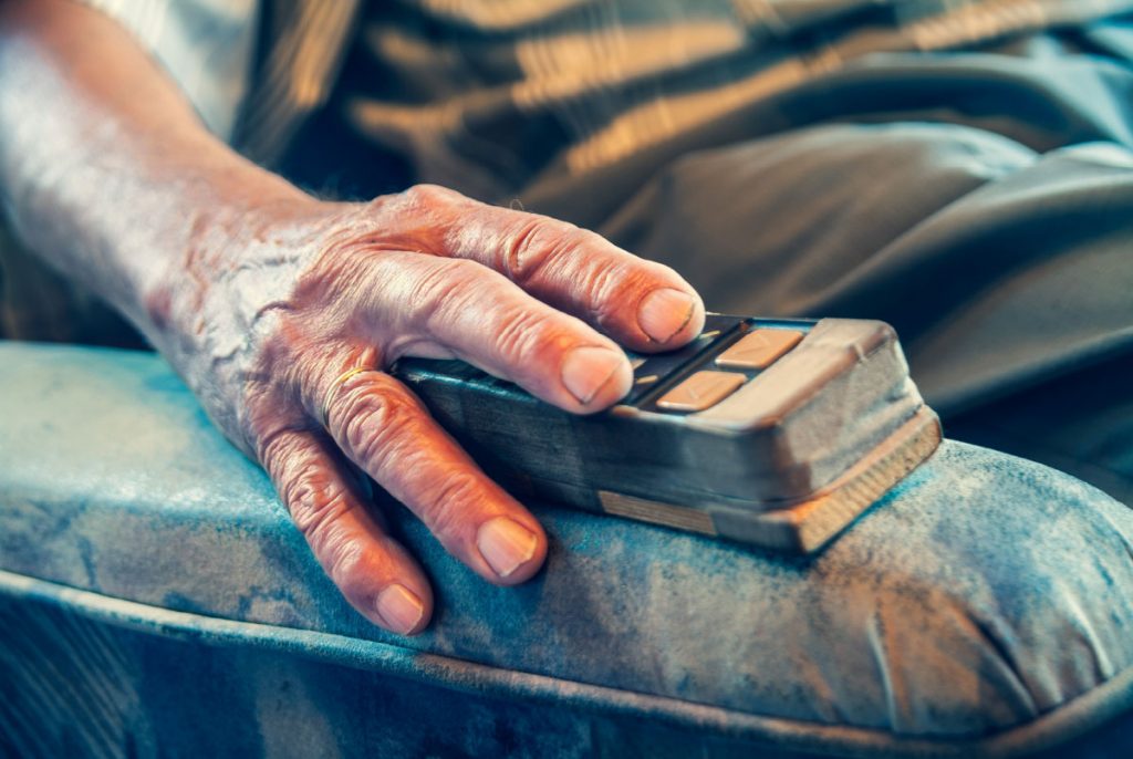 A hand resting on the arm of a chair.