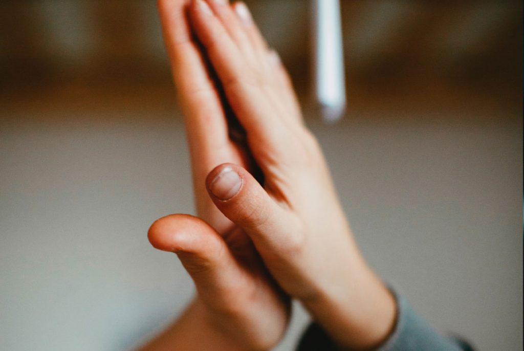 Two hands touching with outstretched palms.