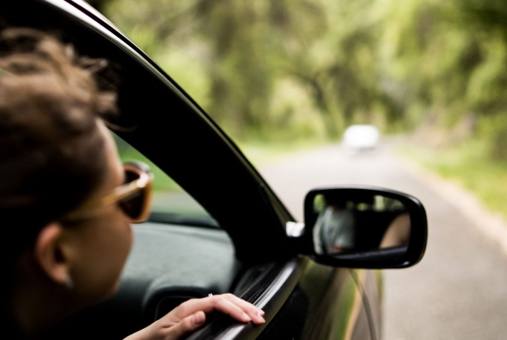 A person looking out of the window of a car.