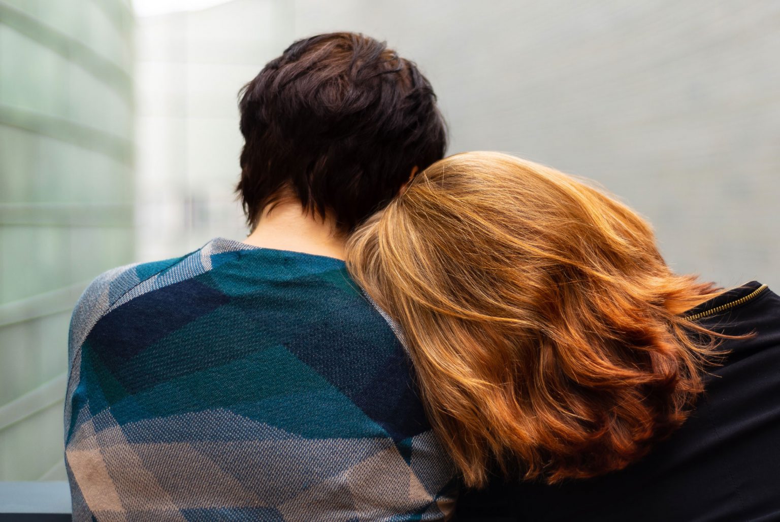 A girl with her head on the shoulder of a man