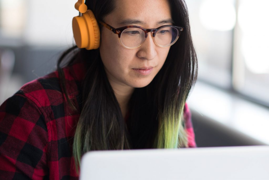 Woman sitting at laptop with headphones on