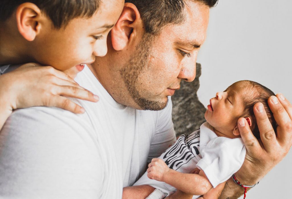 Man holding new born baby.