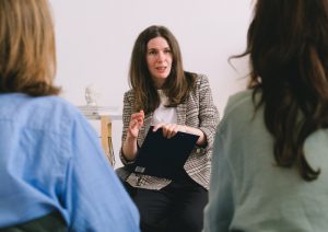 Woman speaking to two people.