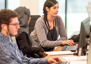 Women working together at computer in office.