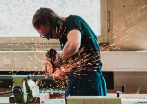 Man grinding metal with sparks flying.