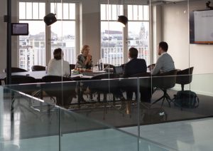 People sitting at boardroom table.