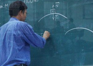 Man drawing on chalk board.