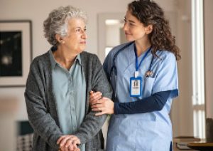 Nurse helping elder woman to walk.