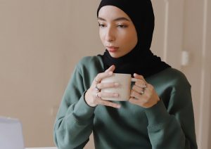 Young woman drinking coffee at work.