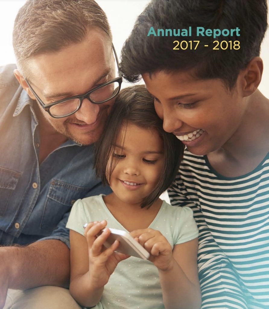 Girl and boy smiling with parent while looking at something a phone together.