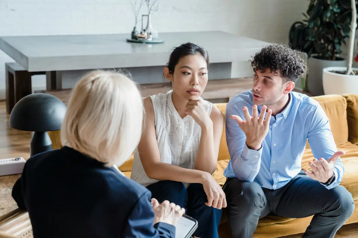 couple sitting on couch talking to counsellor