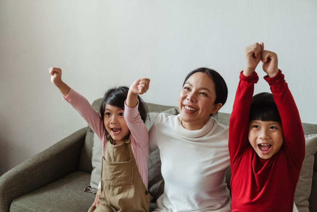 Mother and two children sitting happily on the couch