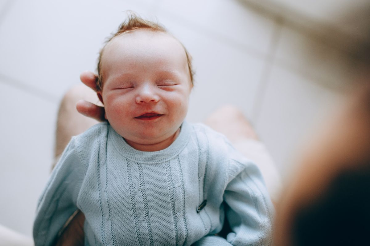 New born baby wearing blue jumper