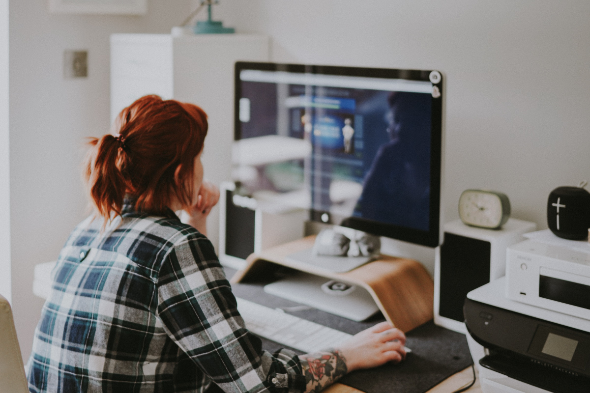 Female professional at a computer, representing the challenges and implications of work addiction.