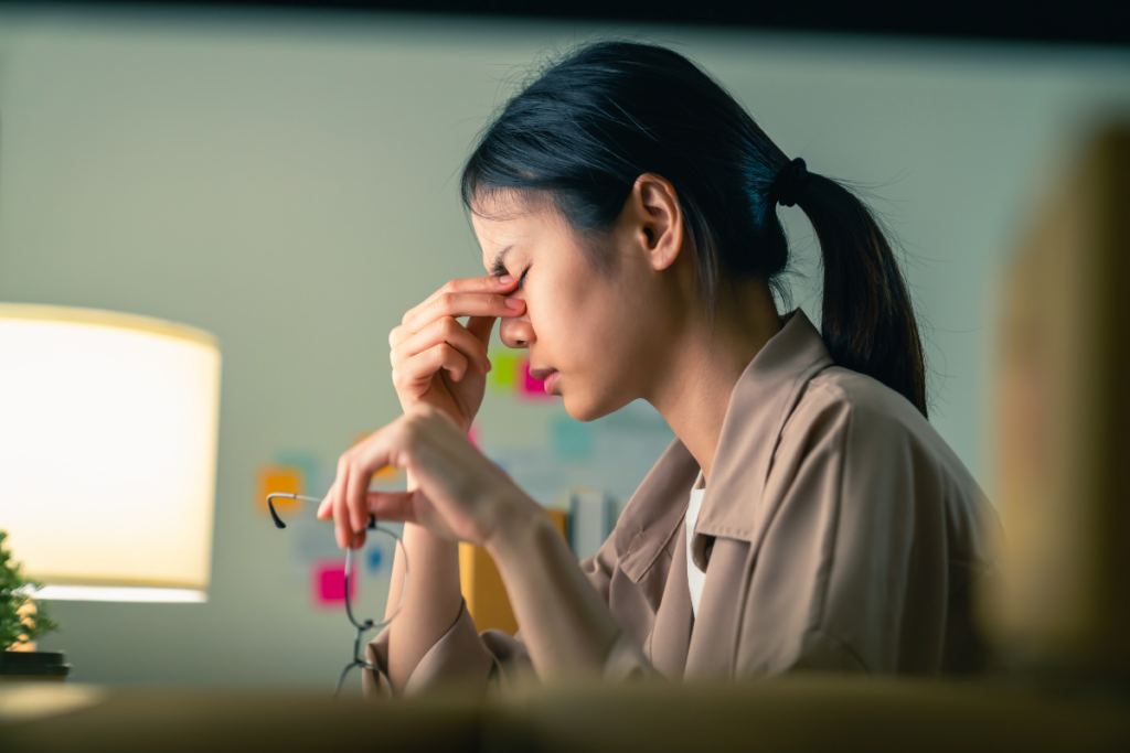 Woman at desk looking stressed.