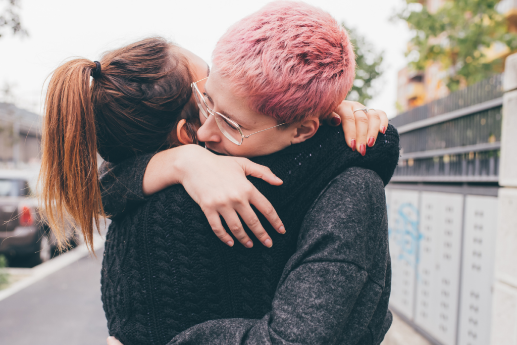 Two people hugging on the street