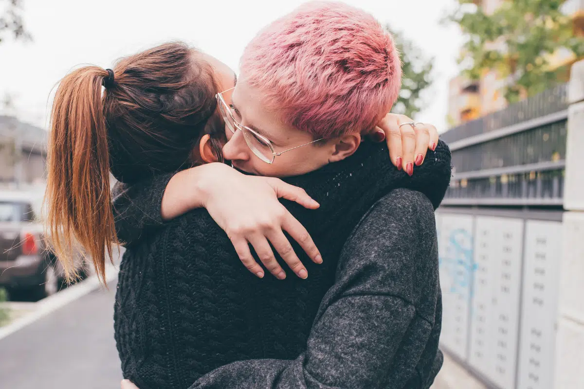 Two people hugging on the street