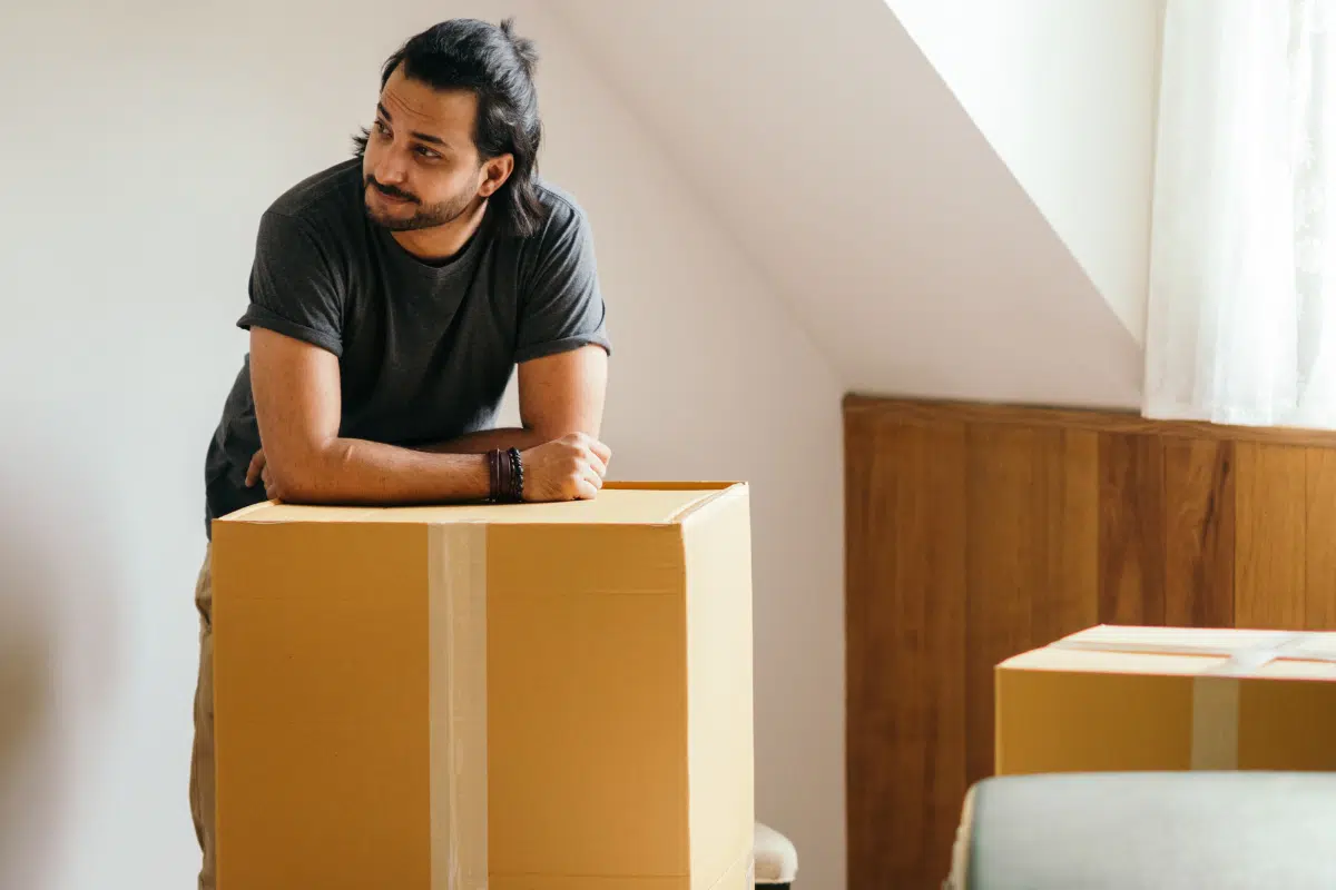 Man leaning on boxes in new apartment