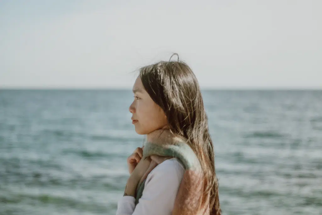 woman standing alone next to ocean