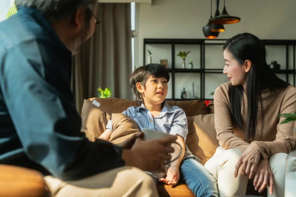 family and child talking while sitting on couches