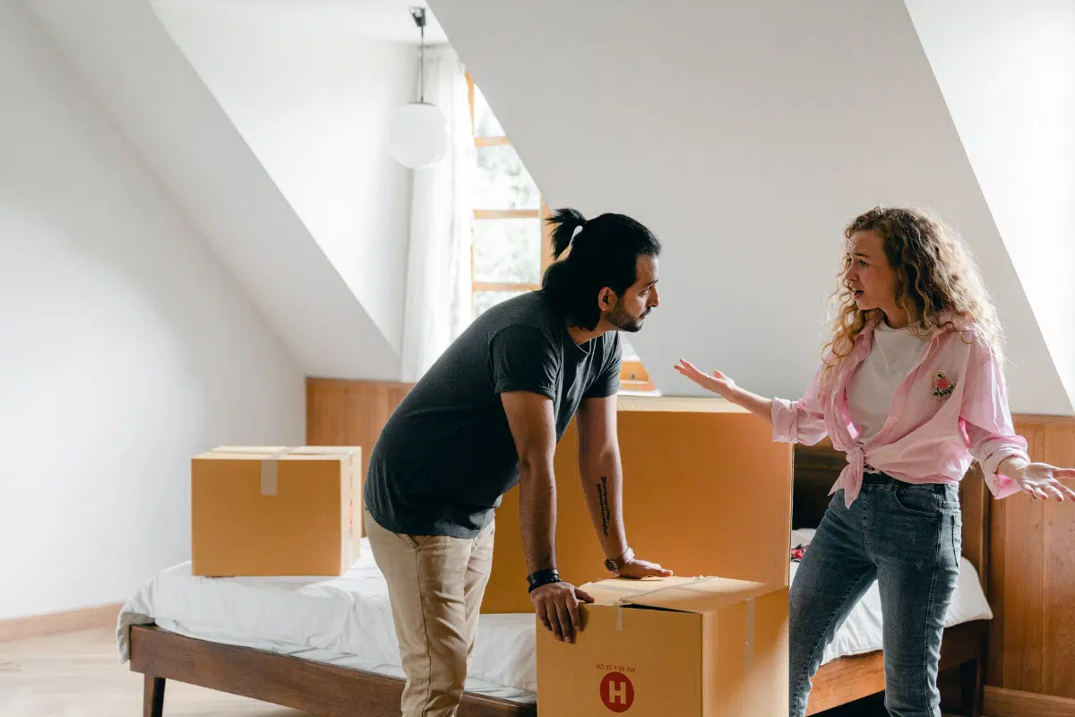 couple arguing as they pack moving boxes
