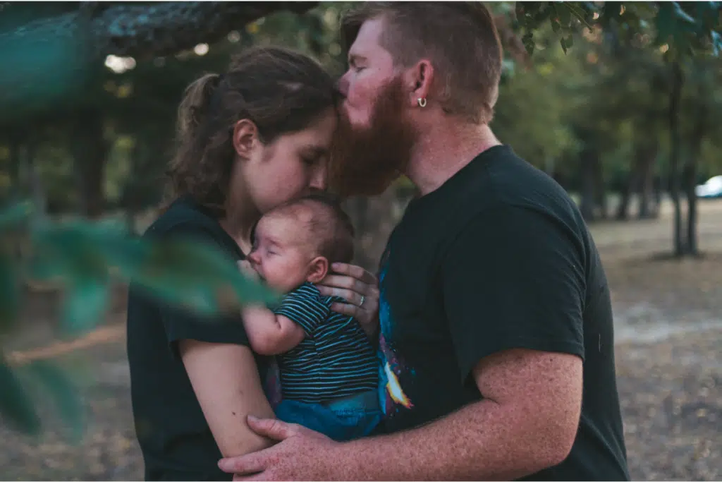 male female parents holding baby