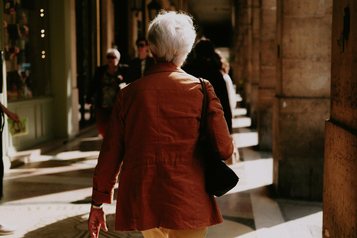 older woman walking through building