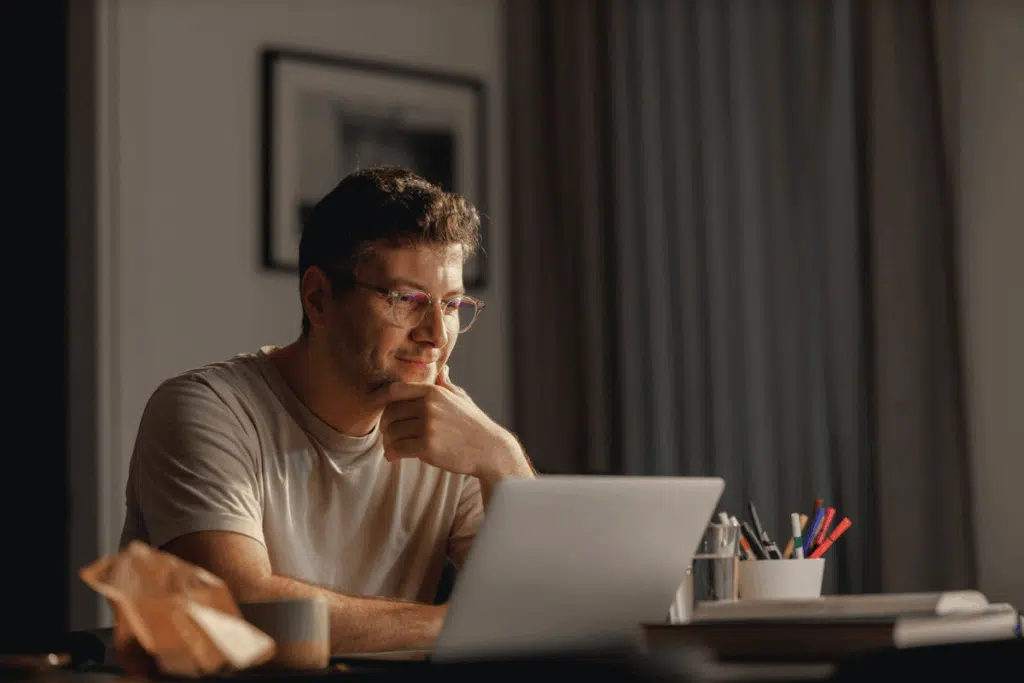 man looking at laptop seated at desk