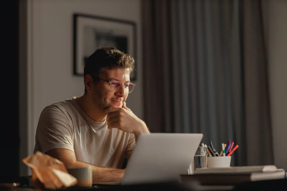 man looking at laptop seated at desk